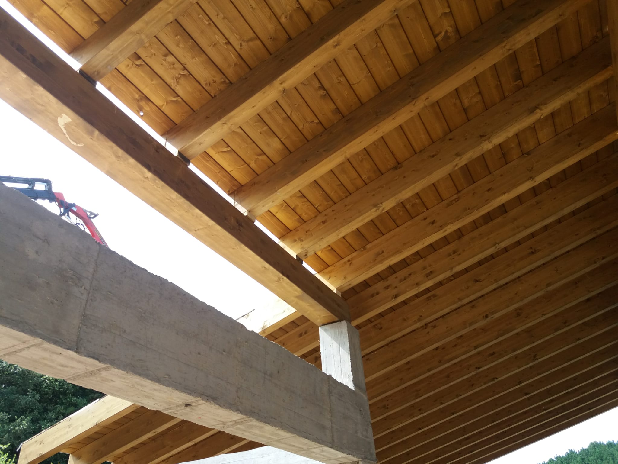 Construcción completa de la estructura de madera de una cubierta de 150m2 compuesta por vigas apoyadas en pilares de hormigón, cabios, tabla machihembrada y frentes en madera de abeto.