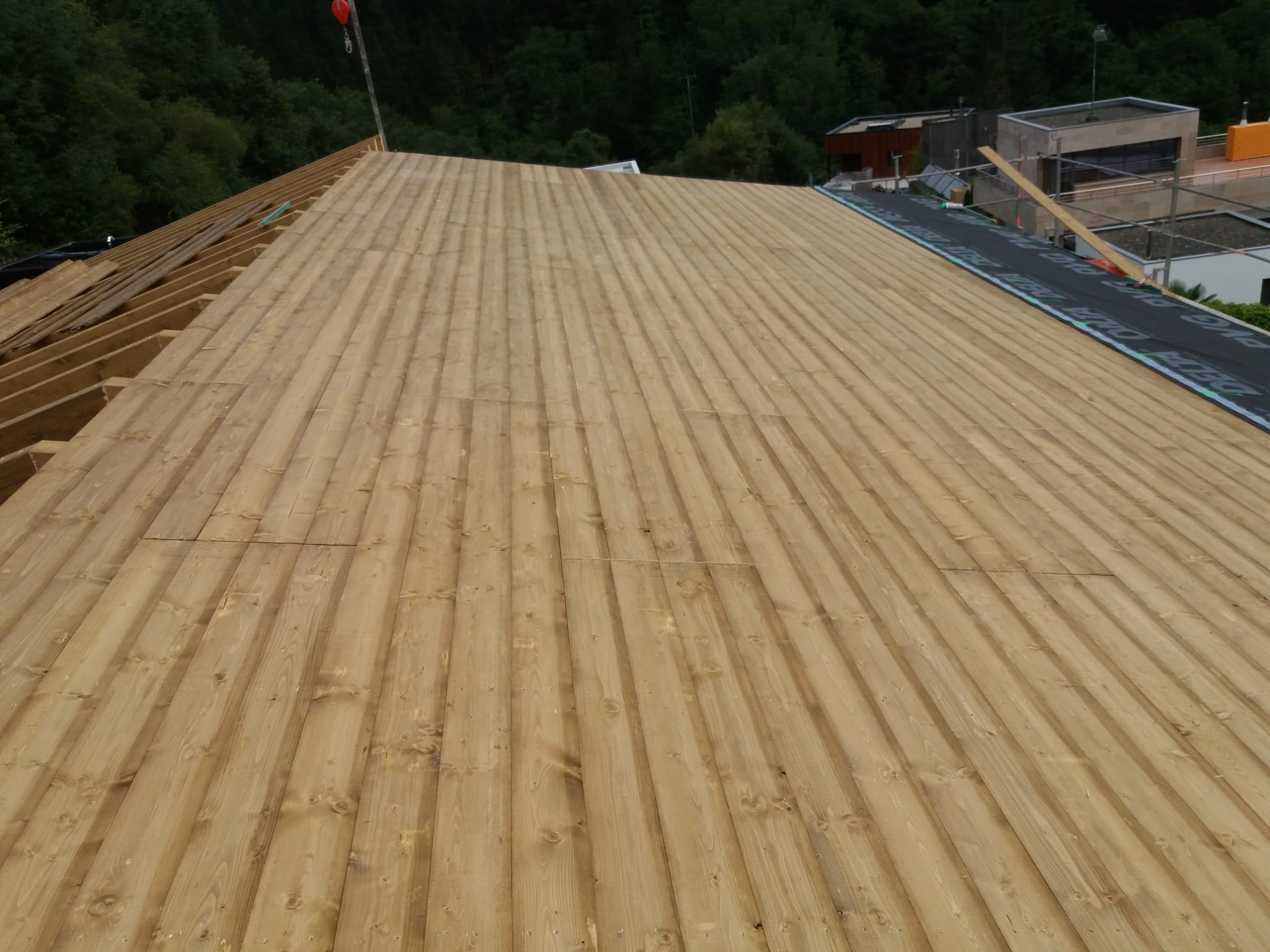 Construcción completa de la estructura de madera de una cubierta de 150m2 compuesta por vigas apoyadas en pilares de hormigón, cabios, tabla machihembrada y frentes en madera de abeto.