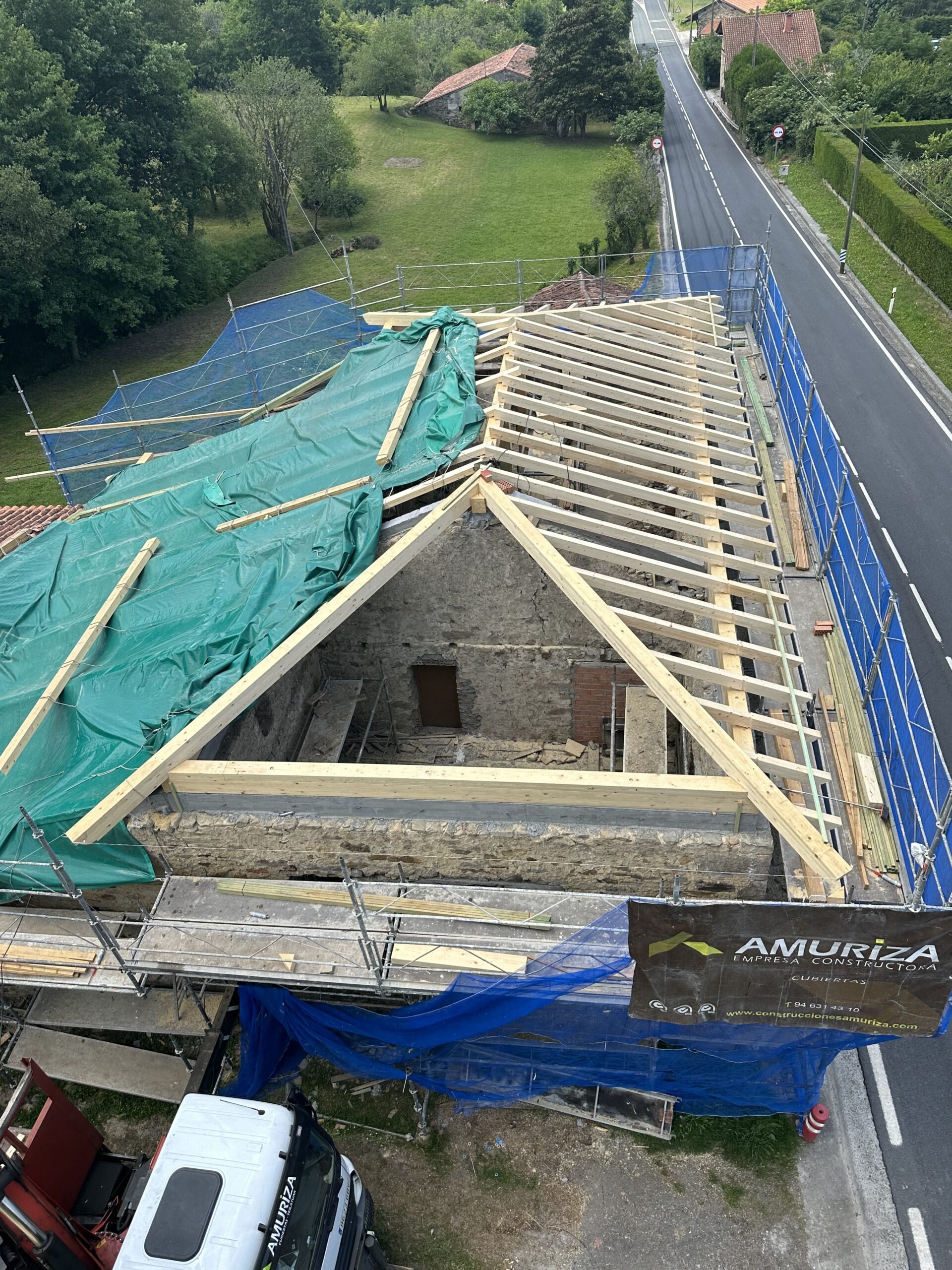 Construcción completa de la estructura de madera de una cubierta de 214,61 m2 de superficie compuesta por postes, zapatas, tijeras, vigas, durmientes, cabios y entablada con tablas de madera de abeto blanco.