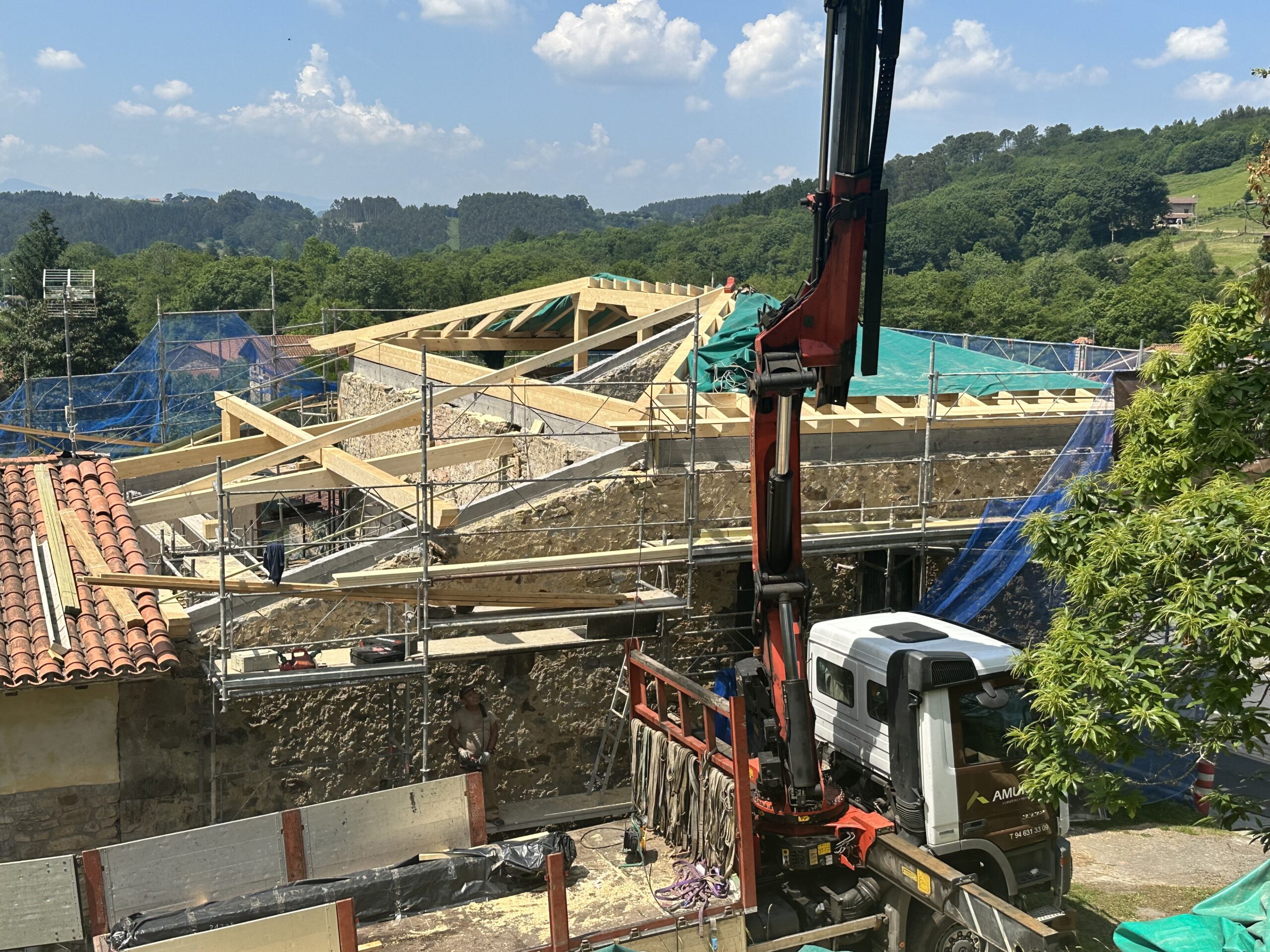 Construcción completa de la estructura de madera de una cubierta de 214,61 m2 de superficie compuesta por postes, zapatas, tijeras, vigas, durmientes, cabios y entablada con tablas de madera de abeto blanco.